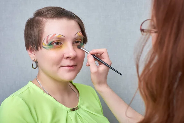 Artista profesional de visage aplicando maquillaje artístico, detrás de las escenas en el set — Foto de Stock