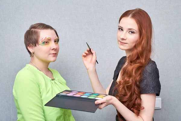 Artista profesional de visage aplicando maquillaje artístico, detrás de las escenas en el set — Foto de Stock