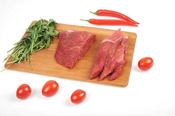 Kesme tahtası ve beyaz arka plan üzerinde izole sebzeler çiğ biftek dilimlenmiş — Stok fotoğraf