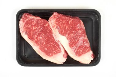 Ham sığır filetosu biftek biftek plastik ambalaj tepsisinde.