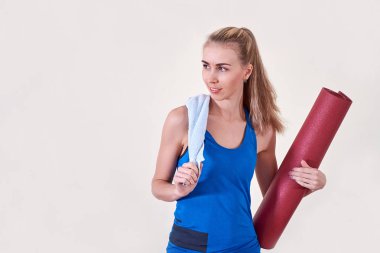 sportif olan kadın haddelenmiş yoga minderi ve havlu. Kopya alanı.