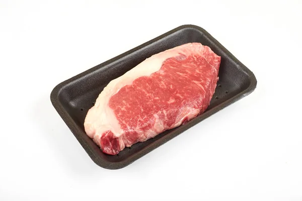 Raw sirloin beef steak in plastic packaging tray. — Stock Photo, Image