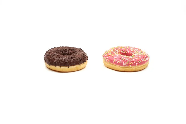 Νόστιμο ντόνατ σοκολάτας και ροζ ντόνατ με πολύχρωμα ψεκάζει σε λευκό φόντο — Φωτογραφία Αρχείου