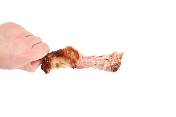 Mão segurando uma perna de frango mordiscado, isolado no fundo branco — Fotografia de Stock