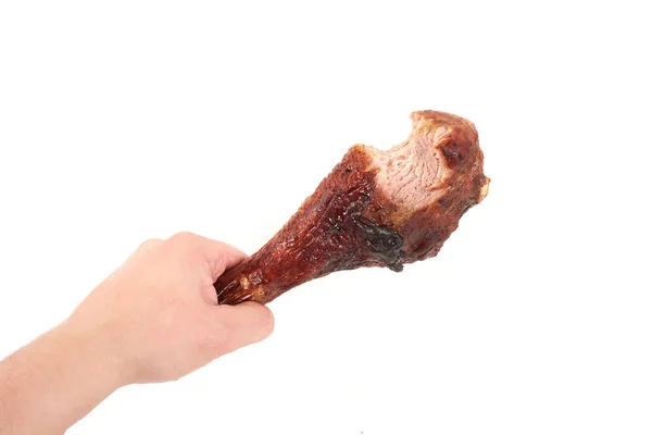 Hand holding been gebraden kip met hapje genomen, geïsoleerd op witte achtergrond. — Stockfoto