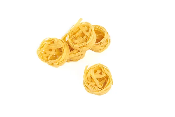 Ninho não cozido de macarrão tagliatelle isolado sobre fundo branco. — Fotografia de Stock