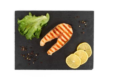 Limon ve kayrak salataya kızarmış som balığı biftek. Beyaz arka plan üzerinde izole