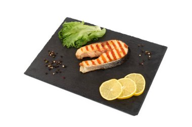 Limon ve kayrak salataya kızarmış som balığı biftek. Beyaz arka plan üzerinde izole