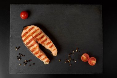 Bir biber, limon ve kopya alanı ile kayrak bir tabakta domates ızgara somon biftek