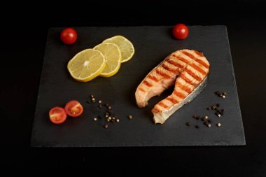 Bir biber, limon ve kayrak tabakta domates ızgara somon biftek.