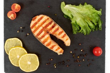 Limon ve kayrak salataya kızarmış som balığı biftek. Beyaz arka plan üzerinde izole