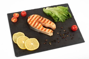 Limon ve kayrak salataya kızarmış som balığı biftek. Beyaz arka plan üzerinde izole