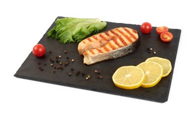 Limon ve kayrak salataya kızarmış som balığı biftek. Beyaz arka plan üzerinde izole