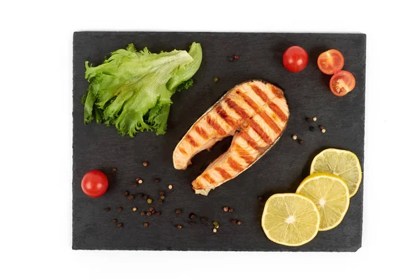 Limon ve kayrak salataya kızarmış som balığı biftek. Beyaz arka plan üzerinde izole