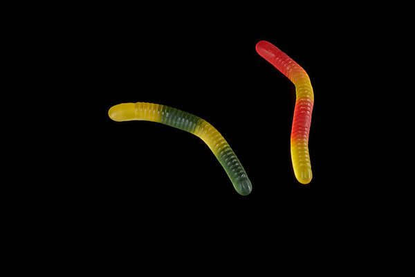 gummy jelly worm candy on a black background.