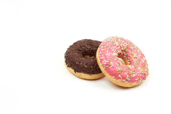 Sabroso donut de chocolate y rosado donut con coloridos espolvoreos sobre fondo blanco — Foto de Stock