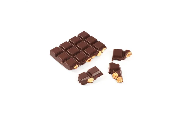 Barra de chocolate escuro com avelãs. Pedaços de chocolate com nozes, isolados sobre fundo branco . — Fotografia de Stock