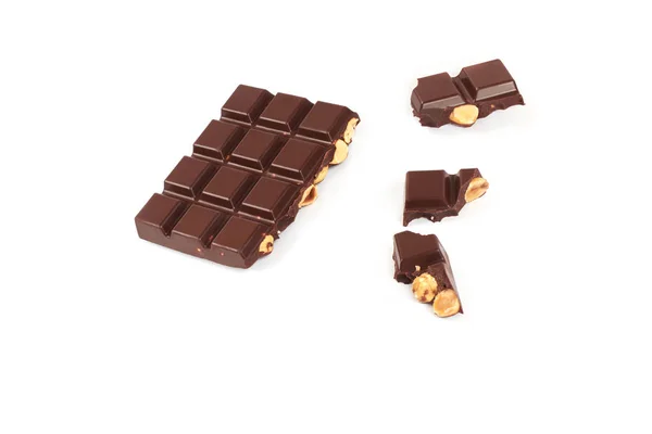 Barra de chocolate escuro com avelãs. Pedaços de chocolate com nozes, isolados sobre fundo branco . — Fotografia de Stock