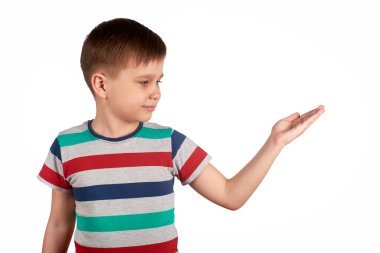 Küçük çocuk beyaz arka planda izole edilmiş bir şeyi işaret ediyor. Boşluğu kopyala.