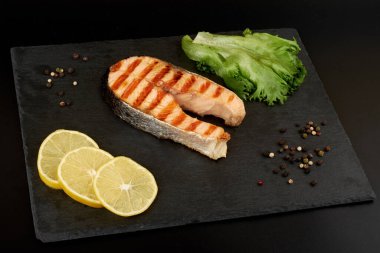 Limonlu ızgara somon bifteği, domates ve salata..