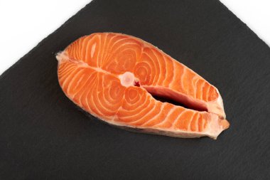 Somon bifteği çiğ balık pişirmeye hazır. Siyah tahta üzerinde üst görünüm.