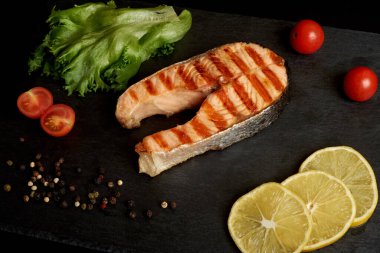 Limonlu ızgara somon bifteği, domates ve salata..