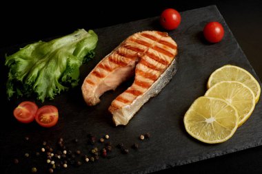 Limonlu ızgara somon bifteği, domates ve salata..