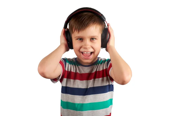 Criança ouve sua música favorita em fones de ouvido e dança para ele, isolado em fundo branco. Conceito de lazer, música e entretenimento . — Fotografia de Stock