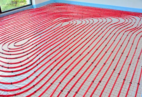 Water underfloor heating pipes on the silver reflective foil in house construction.