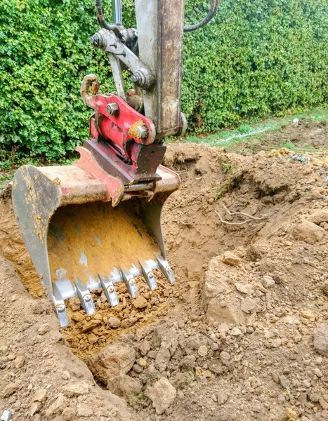 挖掘机铲斗在花园大洞挖土 — 图库照片