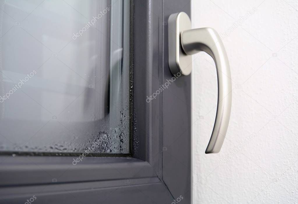 Closeup of the winter condensation on the inside of a window, insulation failure. A window glass covered with condensation drops.