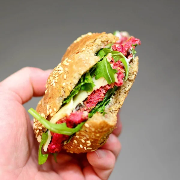 Kezében egy cékla hamburger, a sült saláta kitûnõ — Stock Fotó