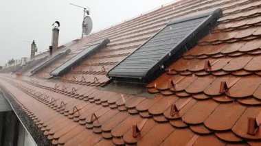 Şiddetli yağmur fırtınası sırasında çatıya düşen yağmur damlaları ve pencereler ağır çekim klipleri..