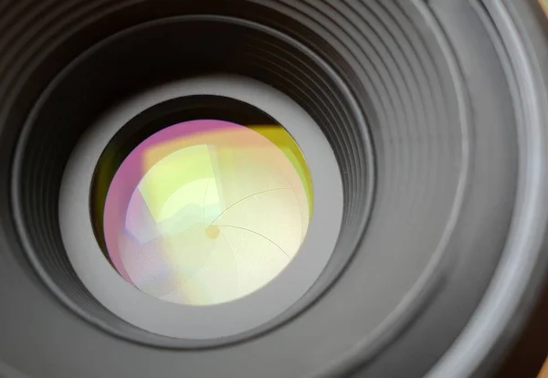 Closeup of aperture in camera lens with light reflection effect.