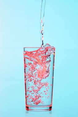 Cam, mavi ve kırmızı ışık dökülen su akışı