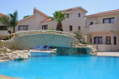 Lüks Yunan Resort'ta yüzme havuzu üzerinde taş köprü