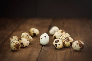 Tahta arka planda birkaç bıldırcın yumurtası.