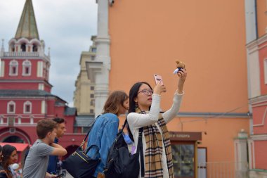 Moskow, Rusya - 21 Ağustos 2018: Güzel Asyalı kız sokakta küçük bir oyuncağın fotoğrafını çekiyor