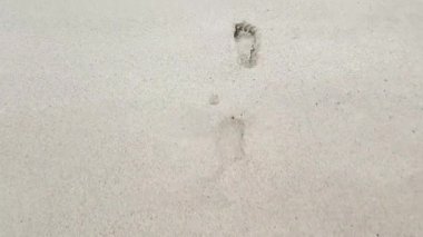 Kumda bir kızın ayak izleri.