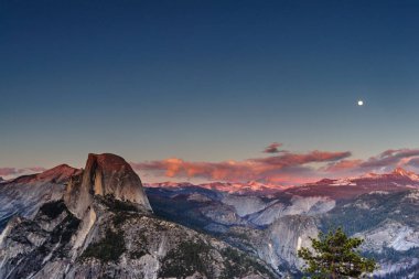 Half Dome ve Yosemite Vadisi panoramik manzaralı. Ay dışardayken günbatımı Altın ışık dağ başında atıldı. Görüntü buzul noktası, Nisan ayı başlarında.