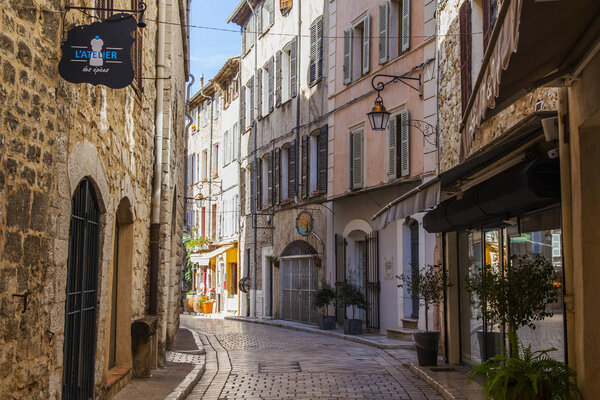 VENCE, FRANCE, 8 марта 2018. Типичная городская улица старых каменных домов небольшого горного городка в Провансе
. 