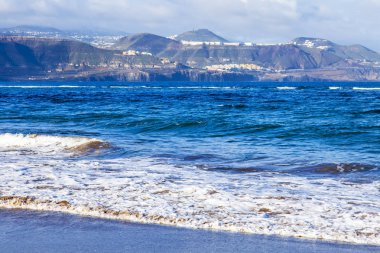 Bir sörf, bulutlu havalarda Atlantik Okyanusu kıyısında pitoresk dalgalar