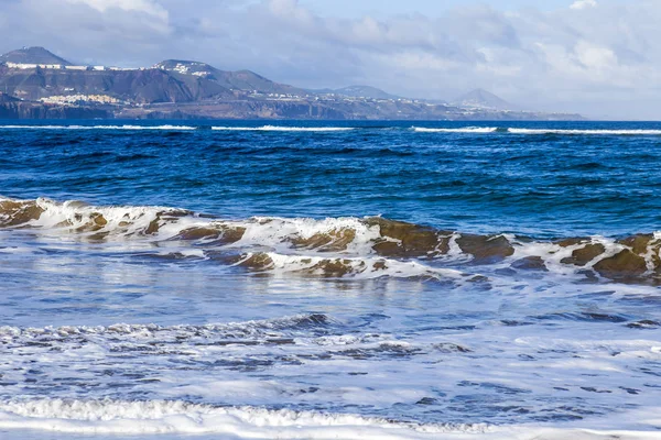 Picturesque waves of a surf at the coast of the Atlantic Ocean in cloudy weather