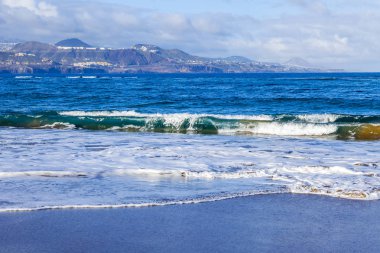 Bir sörf, bulutlu havalarda Atlantik Okyanusu kıyısında pitoresk dalgalar