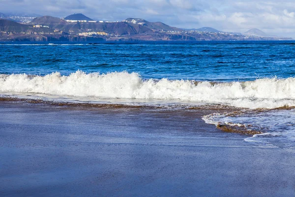 Picturesque waves of a surf at the coast of the Atlantic Ocean in cloudy weather