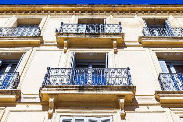 Aix-en-Provence, FRANCE,6 of March, 2018. The sun lights a facade of the old building with a beautiful openwork balcony