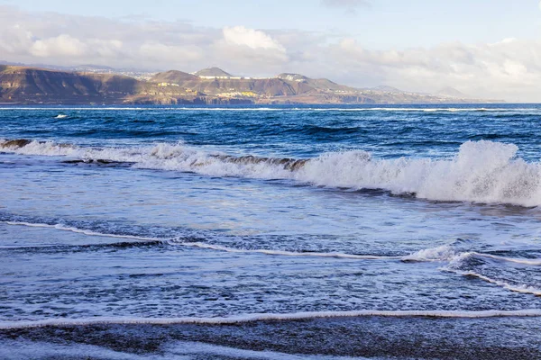 Picturesque waves of a surf at the coast of the Atlantic Ocean in cloudy weather