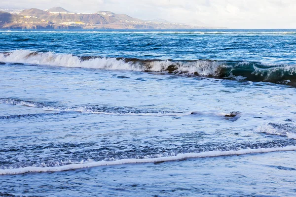 Bir sörf, bulutlu havalarda Atlantik Okyanusu kıyısında pitoresk dalgalar