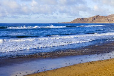Bir sörf, bulutlu havalarda Atlantik Okyanusu kıyısında pitoresk dalgalar