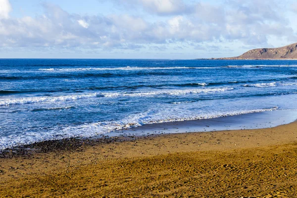 Bir sörf, bulutlu havalarda Atlantik Okyanusu kıyısında pitoresk dalgalar